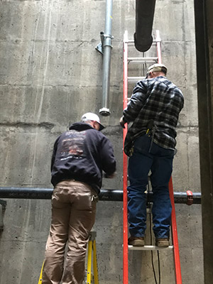 Facilities employees on ladders